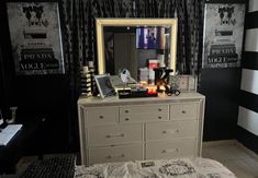 a bedroom with black and white walls, striped curtains, an old dresser and mirror