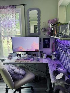 a desk with a computer on top of it in a room filled with stuffed animals