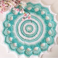 a crocheted doily is shown with flowers in the middle and on top