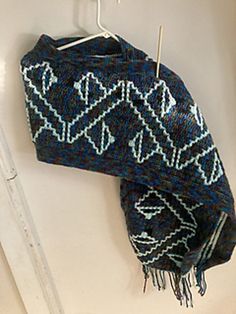 a blue and white scarf hanging on a hook with the words ramak written below it