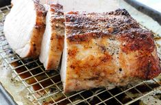 two pieces of meat sitting on top of a metal grill grate covered in seasoning