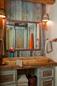 a bathroom sink sitting under a mirror in front of a wooden cabinet and counter top