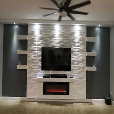 a living room with a fireplace, tv and ceiling fan in the middle of it