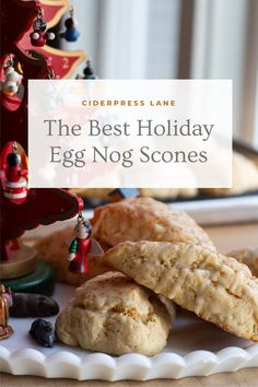 the best holiday egg nog scones on a plate with christmas decorations in the background