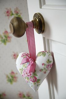 a heart shaped pillow hanging from a door handle