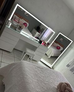 a bedroom with a bed, dresser and mirror on the wall next to each other