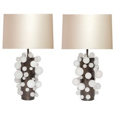 two lamps with white balls on them are next to each other