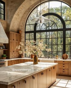 a large kitchen with an arched window and marble counter tops