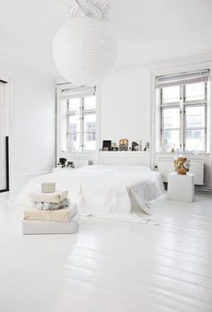 a bedroom with white floors and large windows