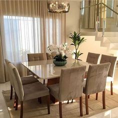 the dining room table is surrounded by beige chairs