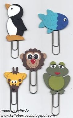 six animal shaped paper clips are on a white surface and one has a blue, green, yellow, orange, and black bird