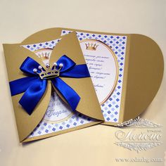 an open card with a blue ribbon and a crown on it