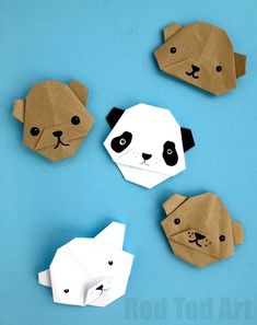 four paper animals on a blue surface with one panda bear and the other polar bear