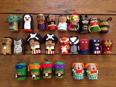 many different toy figures are arranged on a wooden table