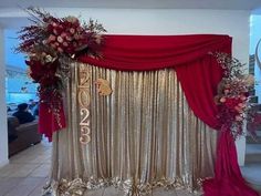 a red and gold stage set up with flowers on the front, draping over it