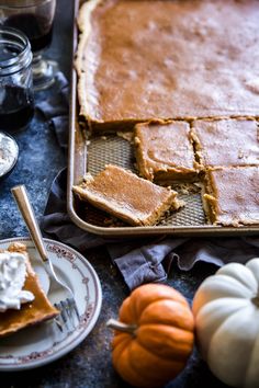 there is a pie on the table with pumpkins and other food items around it