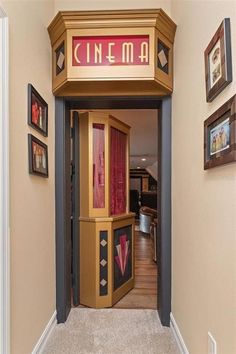 the entrance to an apartment building with red curtains on it's front door, and framed pictures on the wall