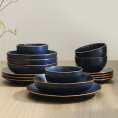 a set of blue and gold dinnerware on a wooden table