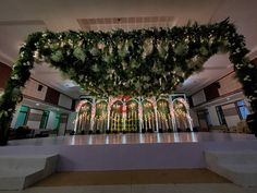 an indoor wedding venue decorated with greenery and lights