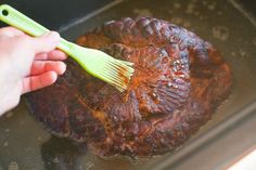 a person is brushing their food with a green toothbrush on top of the meat