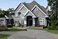 a large gray house with white trim and windows