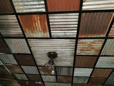 the ceiling is covered in rusty tin and glass panels, with a lightbulb hanging from it's side