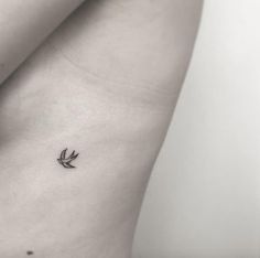 a small tattoo on the back of a woman's stomach