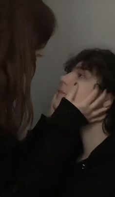 two women are touching each other's faces with their hands in front of them