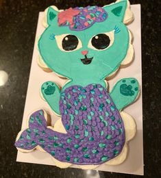 a cake shaped like a mermaid cat sitting on top of a sheet of white paper