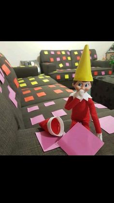 an elf is sitting on the couch with pink sticky notes in front of him and making a funny face