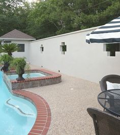 an outdoor patio area with a pool and hot tub