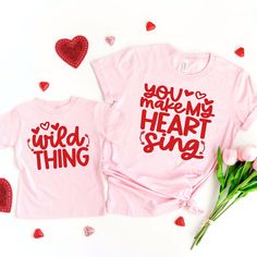 two t - shirts with the words you're my heart song on them next to some flowers