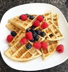 a white plate topped with waffles and berries