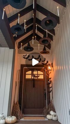 the front porch is decorated for halloween with pumpkins and candles hanging from the ceiling