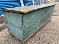 an old wooden chest sitting in front of blue storage units