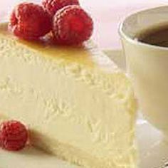 a piece of cheesecake with raspberries and a cup of coffee