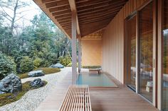 a wooden walkway leading to a covered area with rocks and trees in the background,