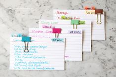 five notepads are lined up on a marble counter top with clippings attached to them