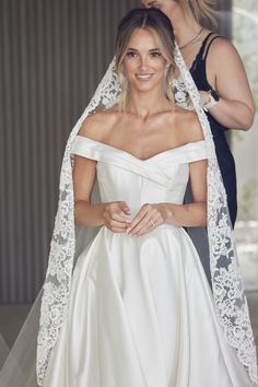 the bride is getting ready to walk down the aisle with her veil draped over her head