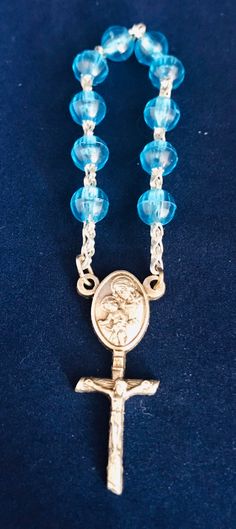 "This is a beautiful blue beaded pocket rosary. This rosary is easy to keep with you so you can recite the rosary while on the go. This mini rosary has a lovely medallion of Mary and Baby Jesus. Below that is a cross with Jesus on it. This is in excellent condition and measures at about 3 3/8\"H." Blue Rosary For Healing, Blue Healing Rosary, Blue Rosary With Round Beads For Healing, Blue Rosary With 8mm Beads For Healing, Adjustable Blue Beaded Rosary, Adjustable Blue Rosary With Miraculous Medal, Blue 108 Beads Spiritual Rosary, Blue Rosary With 8mm Beads And Crucifix, Mini Rosaries