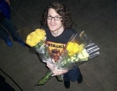 a young man holding flowers in his hands