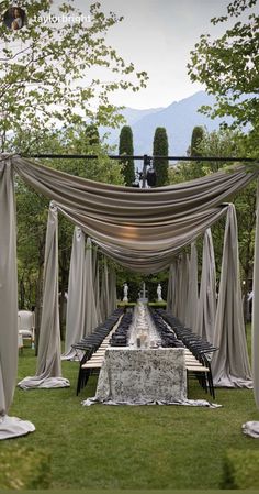 an outdoor dining area with tables and chairs set up for a formal function in the grass