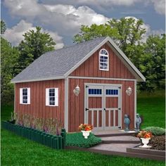 a small red shed sitting on top of a lush green field