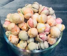 a glass bowl filled with lots of small white and pink flowers on top of a table