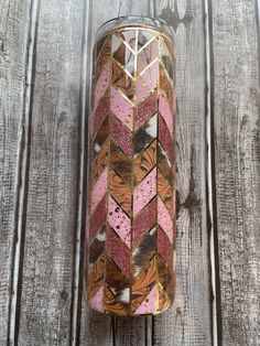 a can that is sitting on top of a wooden table with pink and brown designs