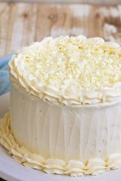 a white frosted cake sitting on top of a plate next to a blue napkin