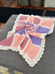 a crocheted blanket sitting on top of a couch