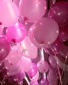 many pink balloons are floating in the air