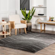 a living room with white walls and wooden flooring, two chairs and a rug on the floor