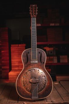 an old guitar sitting on top of a wooden table